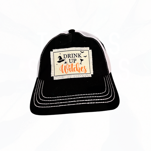 Drink Up Witches patch on C.C Black & White Trucker Hat